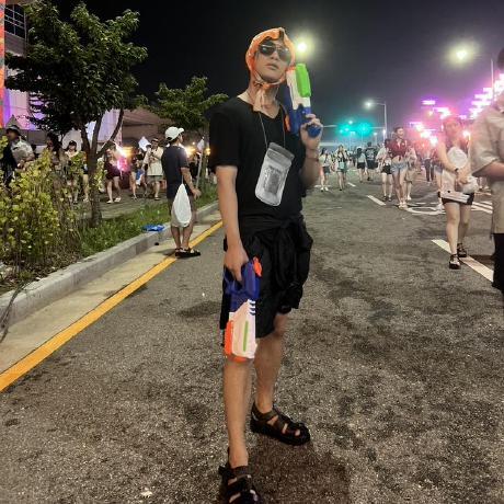 Yongjun Teo Choi at a summer night festival holding water guns